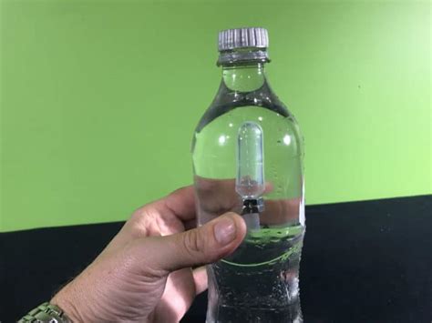 why slightly squeezing plastic bottle causes test tube to sink|Cartesian diver .